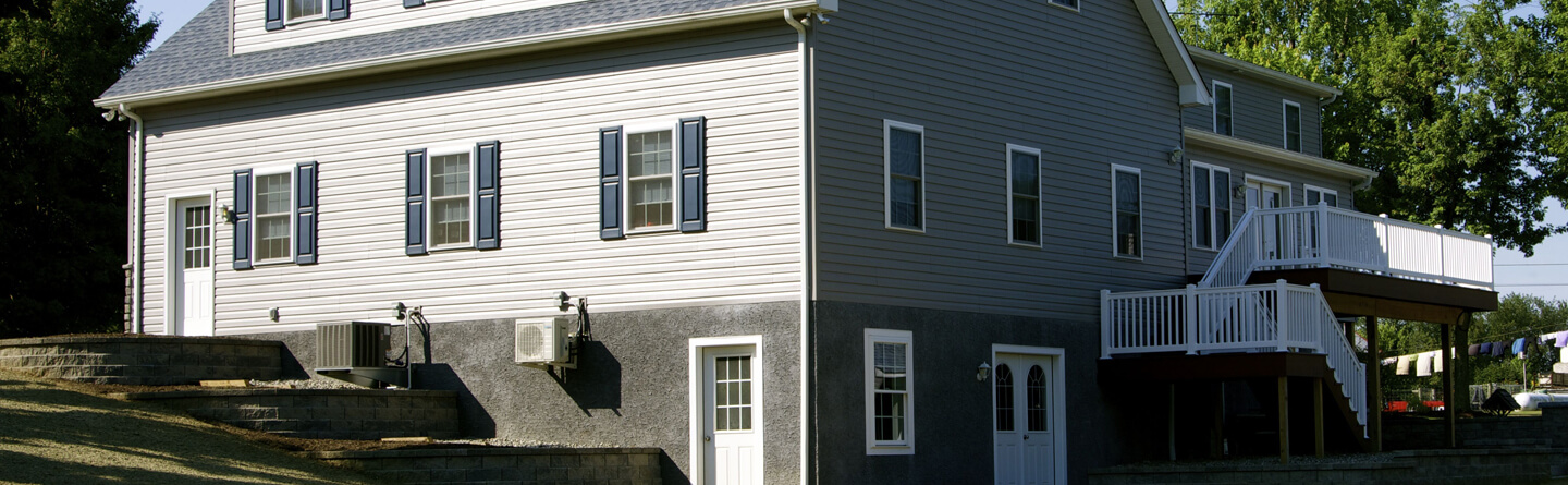 large vinyl and stucco home with second floor deck and railing
