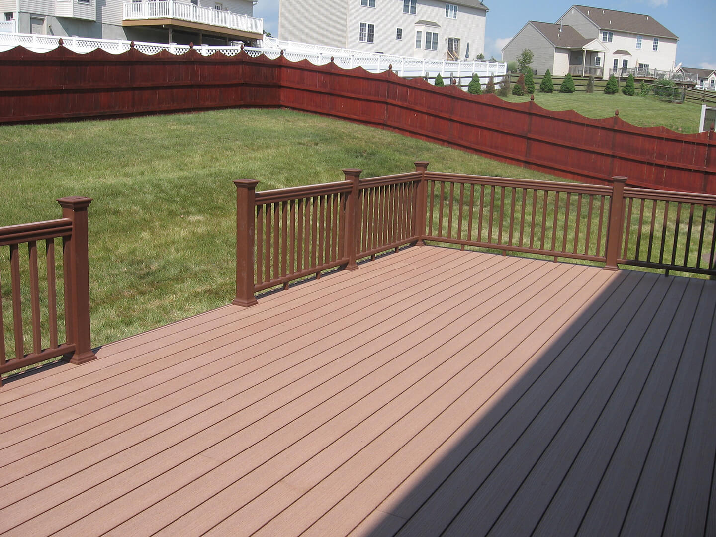 close up of brown timber tech composite deck in fenced in backyard
