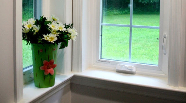 two windows overlooking a yard inside custom home