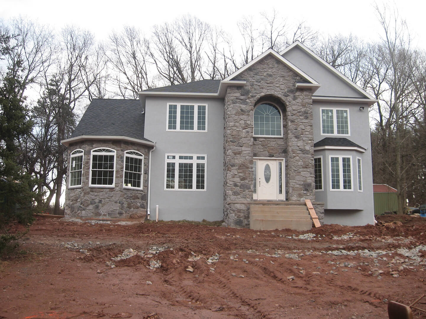 large custom stone and stucco home in berks county on mud construction site