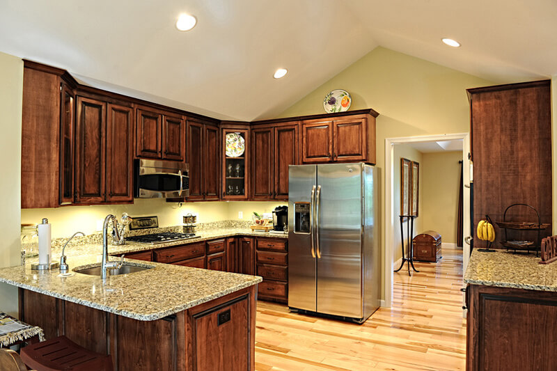 kitchen remodel with wooden cabinets and marble countertops and hardwood floors