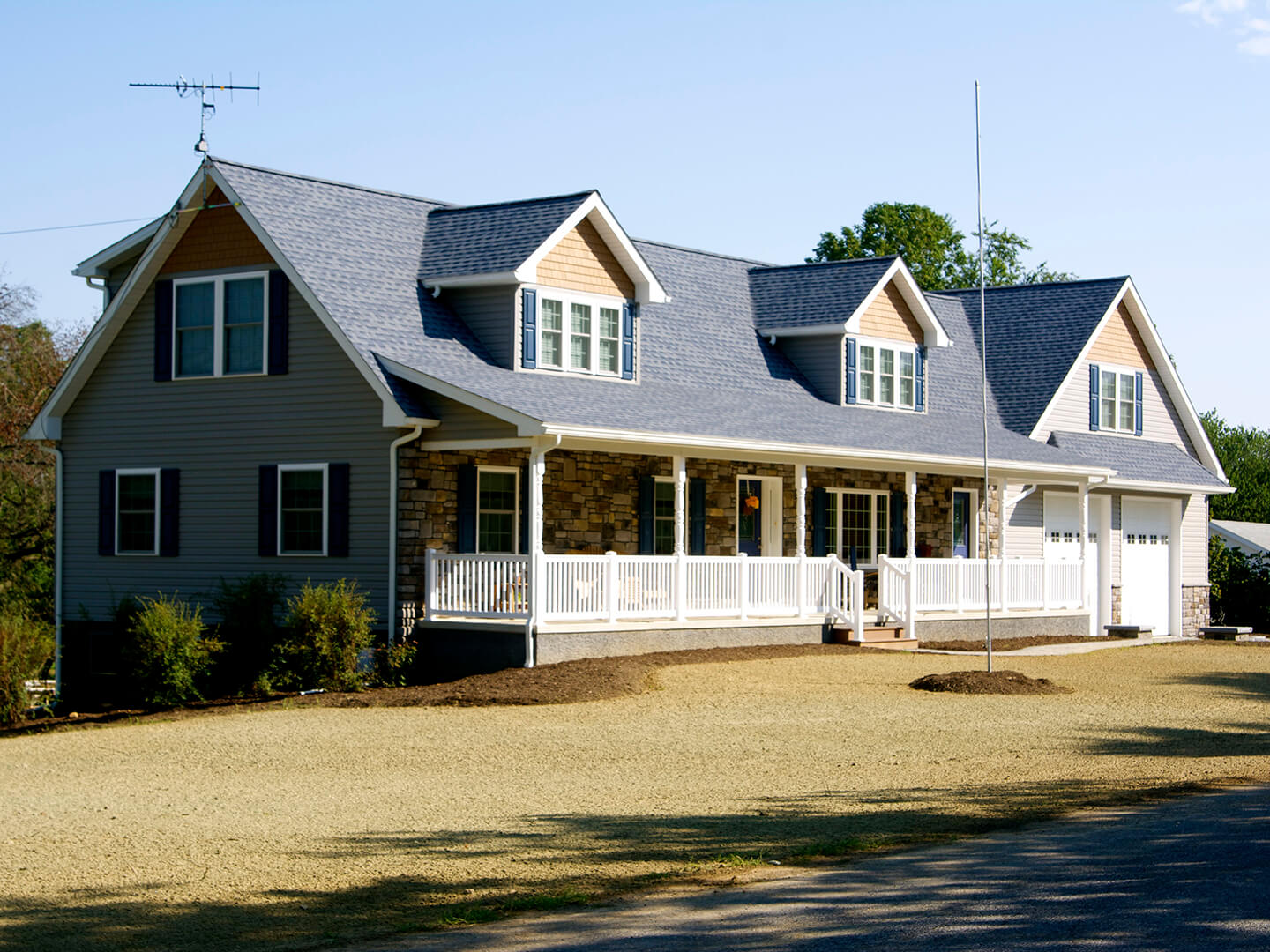 after shot of cape cod style renovation with attached garage