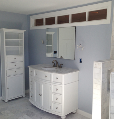 inside look at completed bathroom remodel with white cabinets and drawers